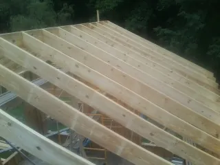 New roof rafters set over an addition before sheathing in Walford