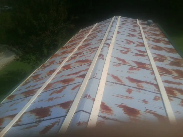 Rusted metal roof panels with new wood purlins before replacement — Storm Damage Roof Repair in Walford by Roofing Brothers