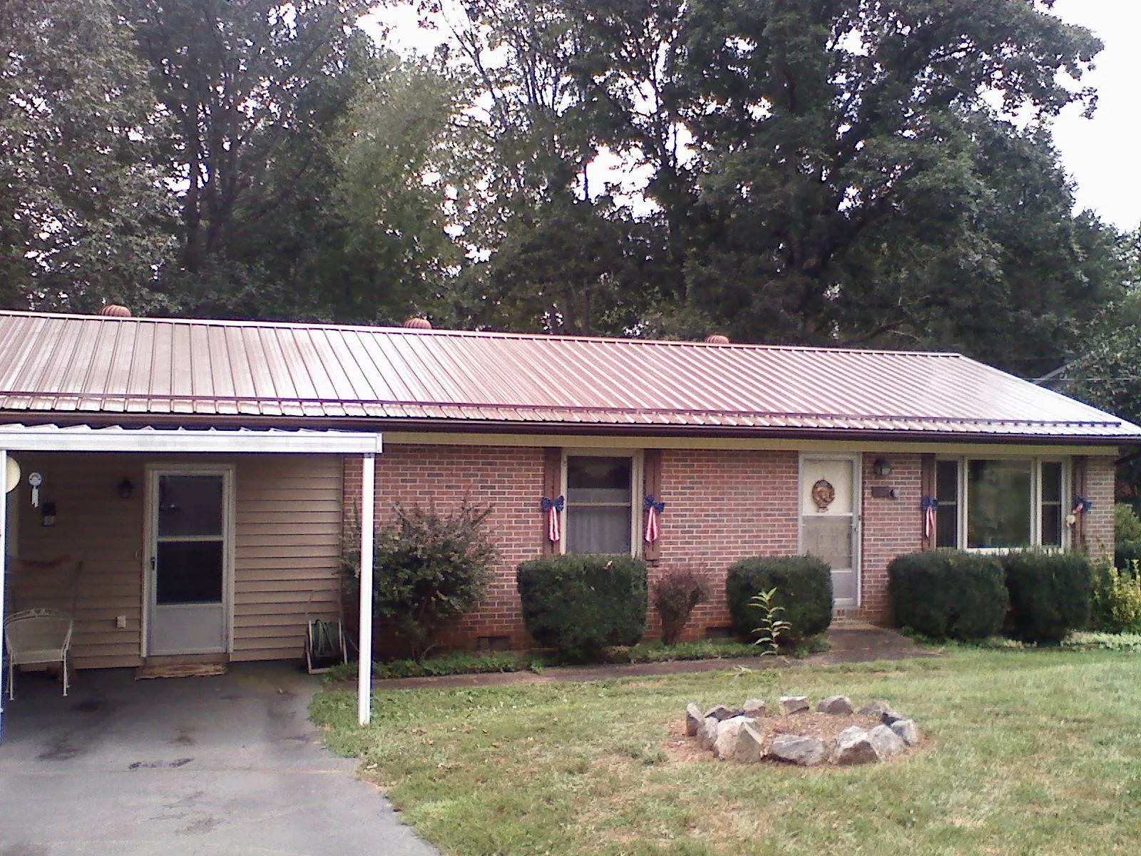 Bronze metal roof and carport on a brick ranch home — Roof Repair work by our crew in Walford